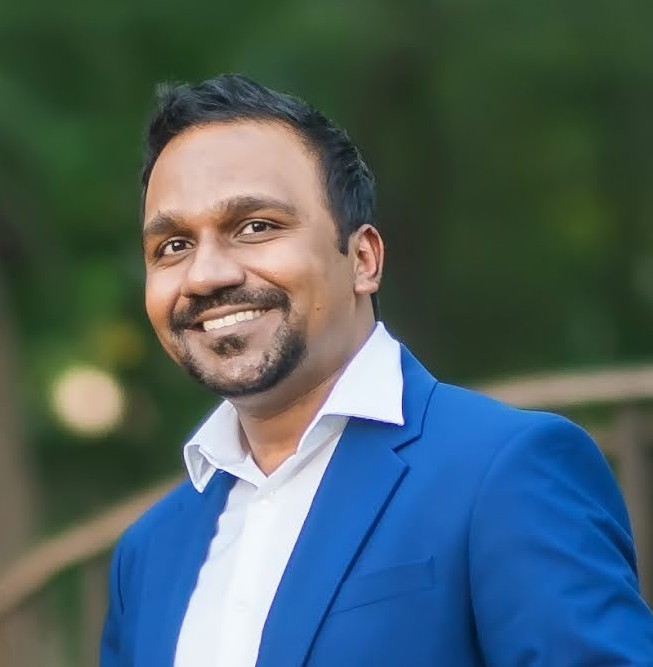 Shyam Uthaman, data and AI leader and author, wearing a blue suit jacket outdoors